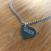 A heart necklace with the word Dance