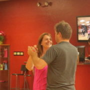 A woman in a pink shirt dancing with a man in gray