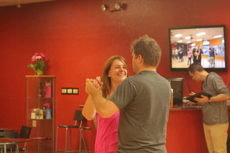 A woman in a pink shirt dancing with a man in gray